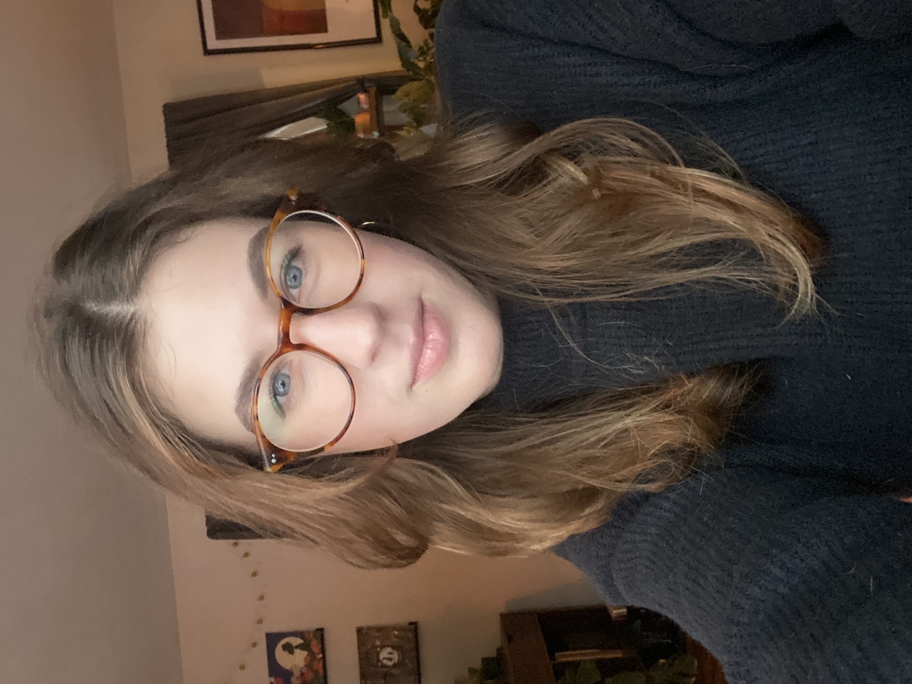 Selfie of Megan Knapp, a young adult woman with medium brown hair and roundish tortoiseshell glasses.